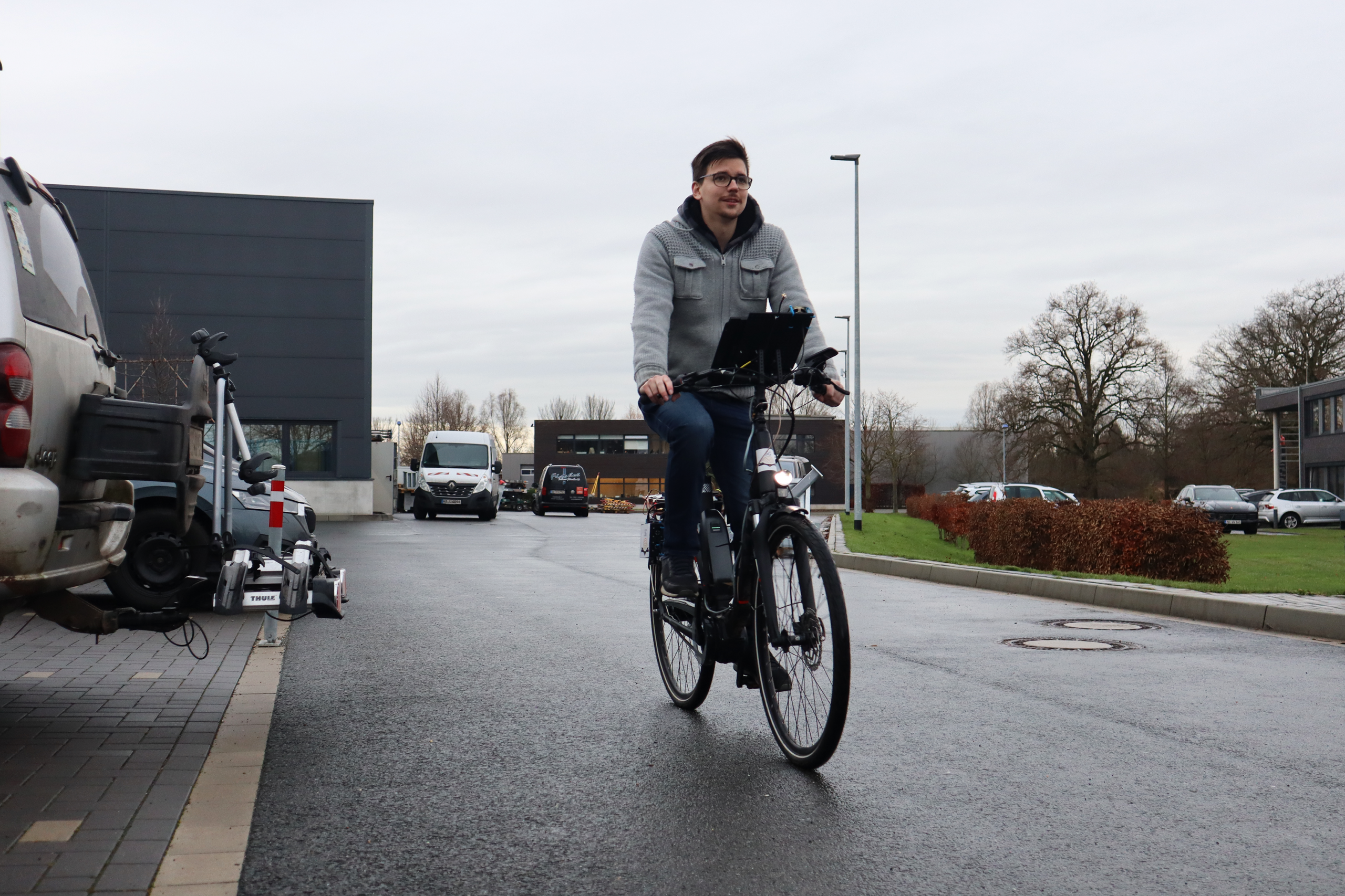 Ein Fahrradfahrer fährt über einen Parkplatz