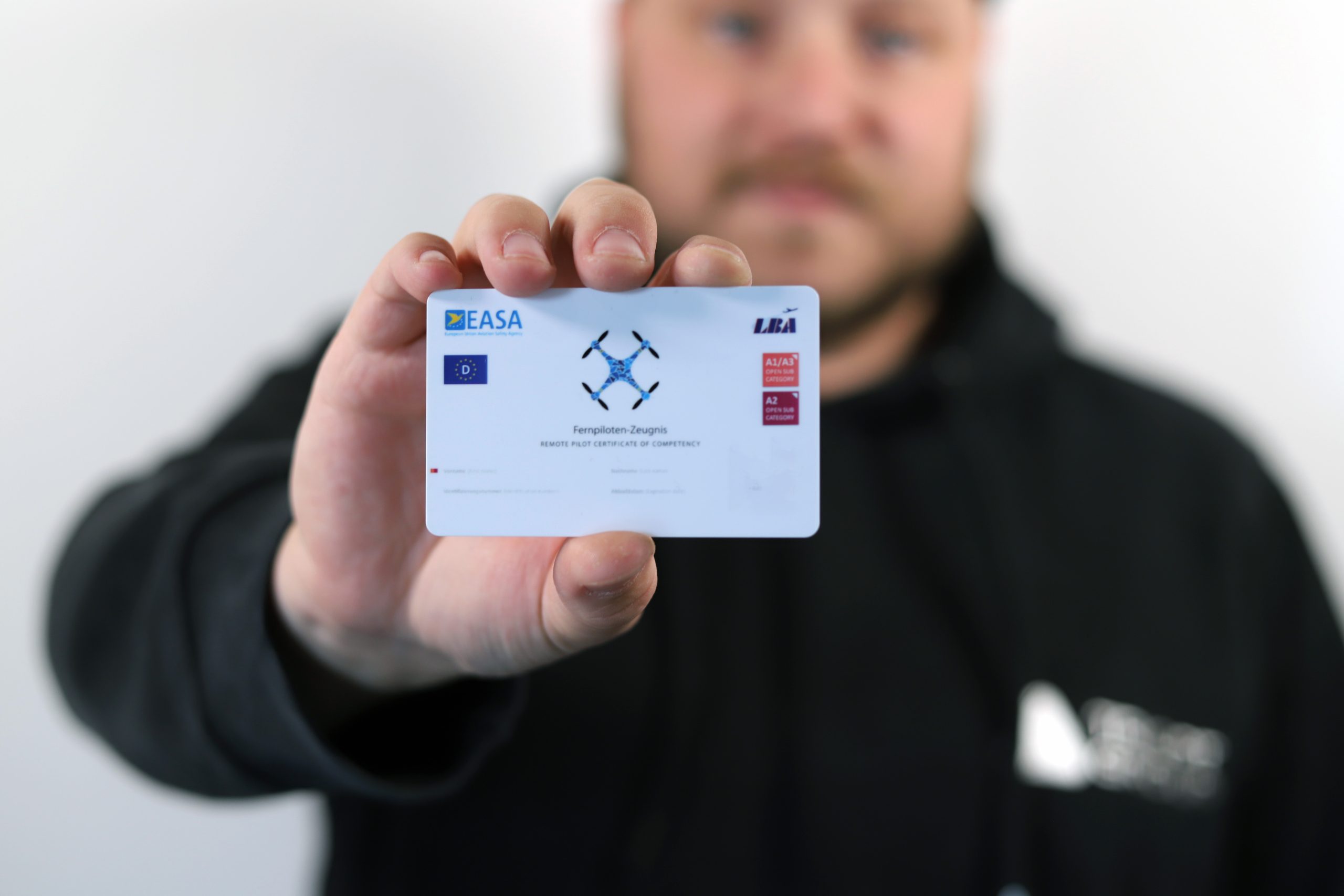 Ein Mitarbeiter der Triopt Group präsentiert sein Fernpiloten-Zeugnis (Remote pilot certificate of competency)